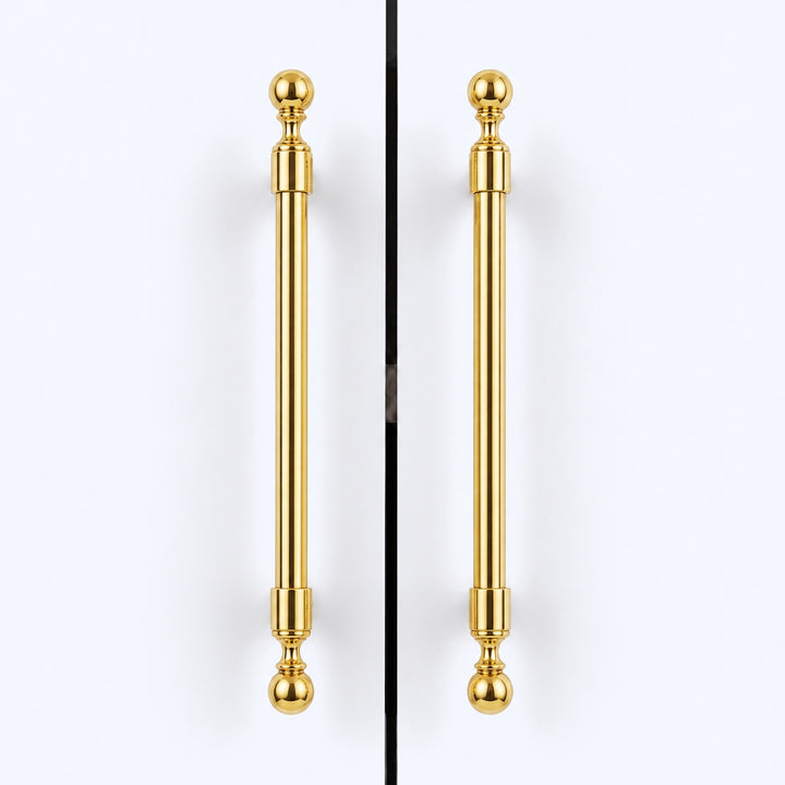 Two matching polished gold cabinet handles with spherical finials, shown vertically side by side against a clean white background.