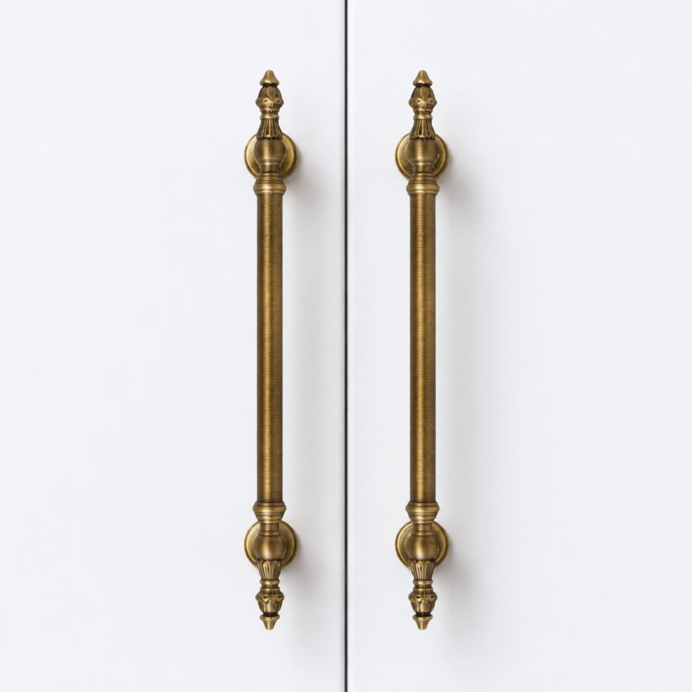 Two long vertical cabinet handles in an antique brass finish, shown side by side against a plain white background.