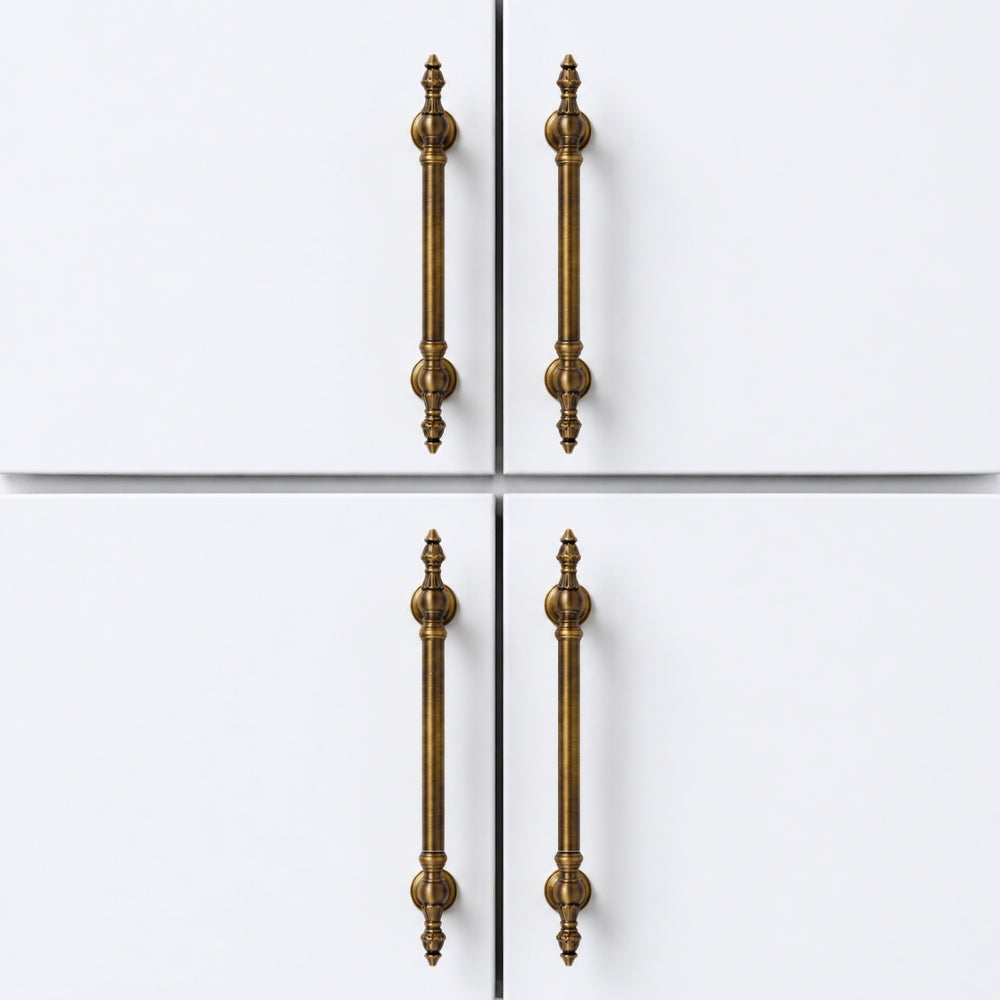 Four long vertical cabinet handles in an antique brass finish, shown on a white four-door cabinet or door front.