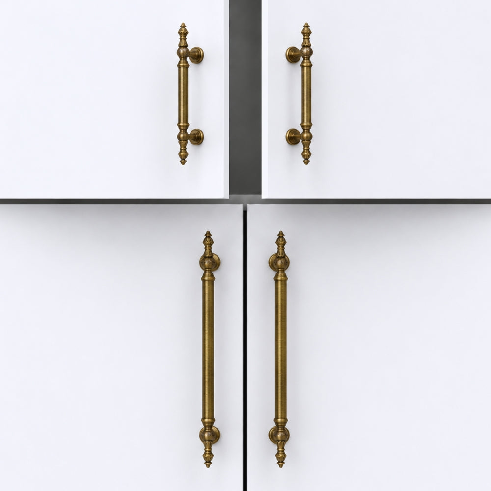 Four cabinet handles in a distressed brass or bronze finish, shown on white doors in a clean studio-style product presentation.