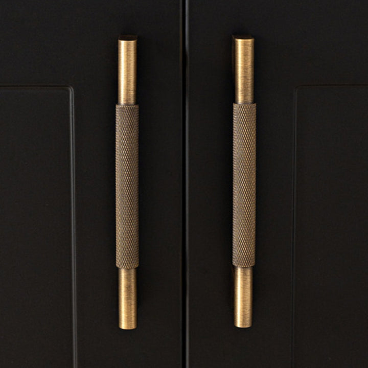 Antique brass 5-inch pull on dark cabinet door
