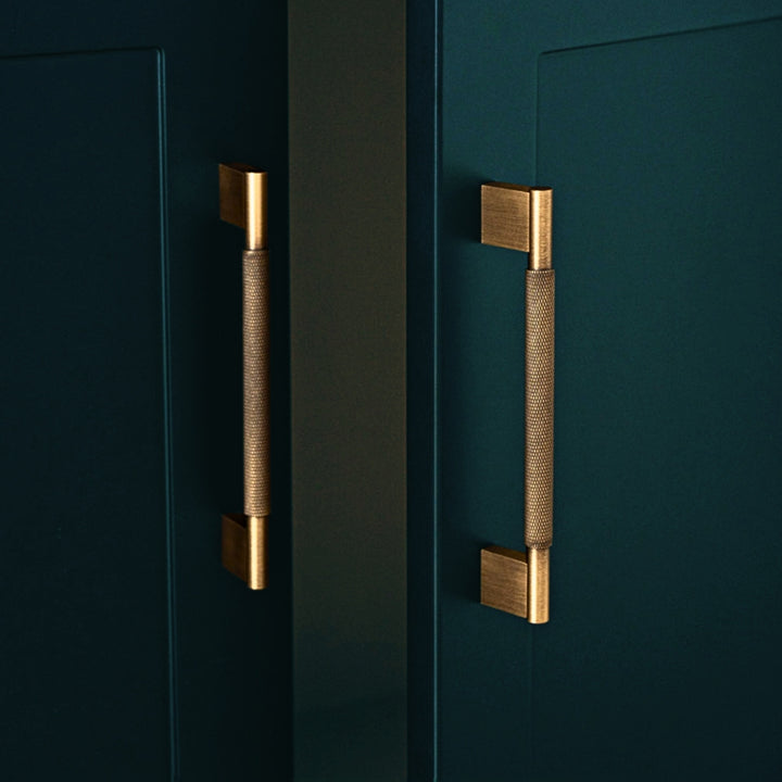 Antique brass 5-inch pull installed on kitchen cabinet